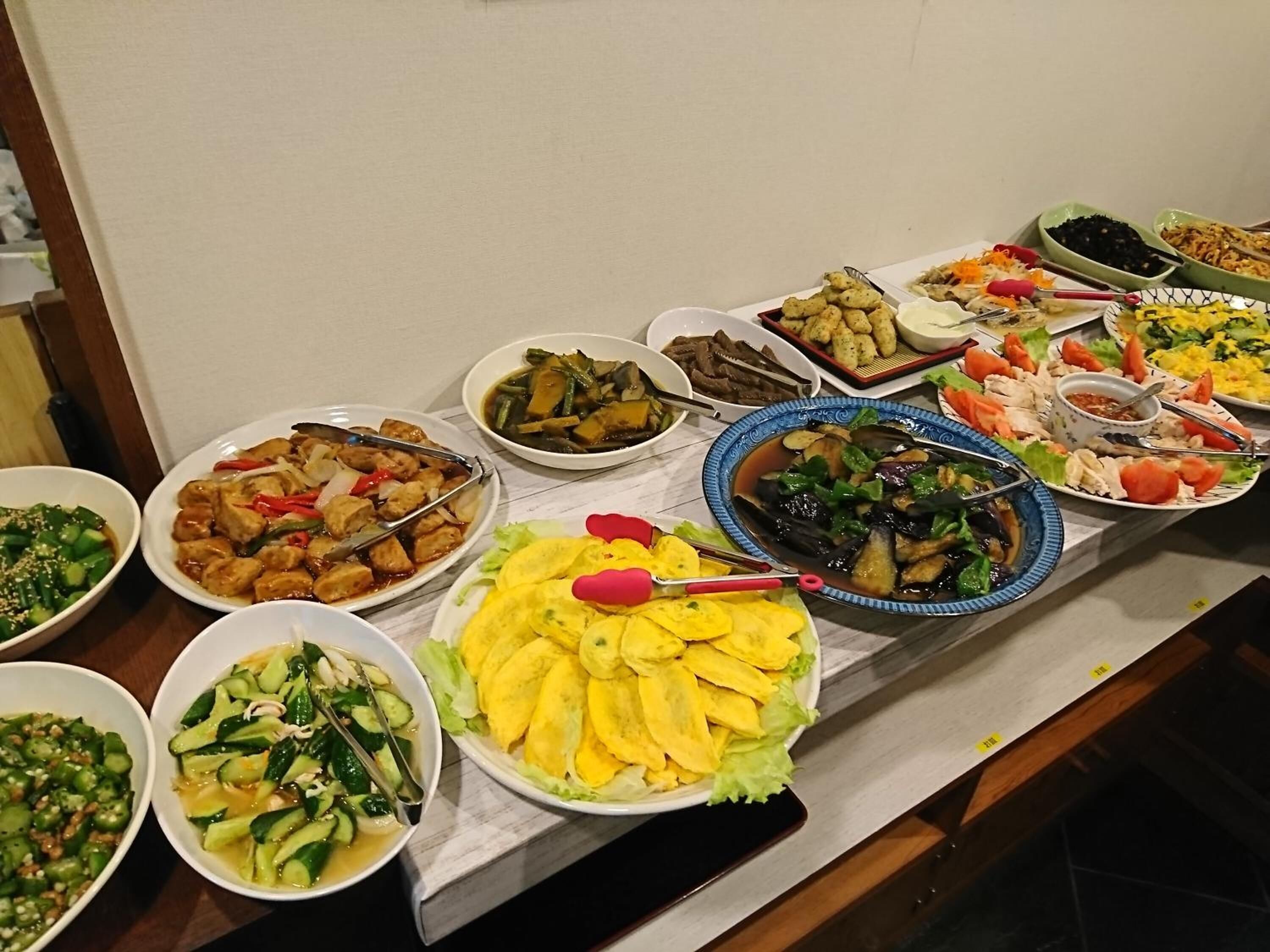 A buffet table with various dishes including vegetables, tofu, and rice.