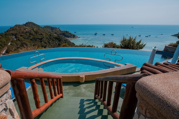 Una piscina al aire libre, sillones reclinables de piscina