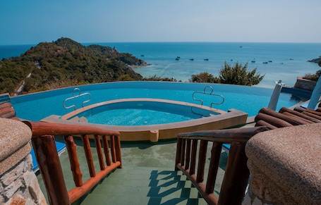 Una piscina al aire libre, sillones reclinables de piscina