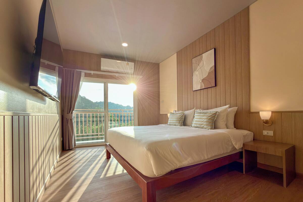 Ein Schlafzimmer mit Bett, Nachttisch und Fenster mit Blick.