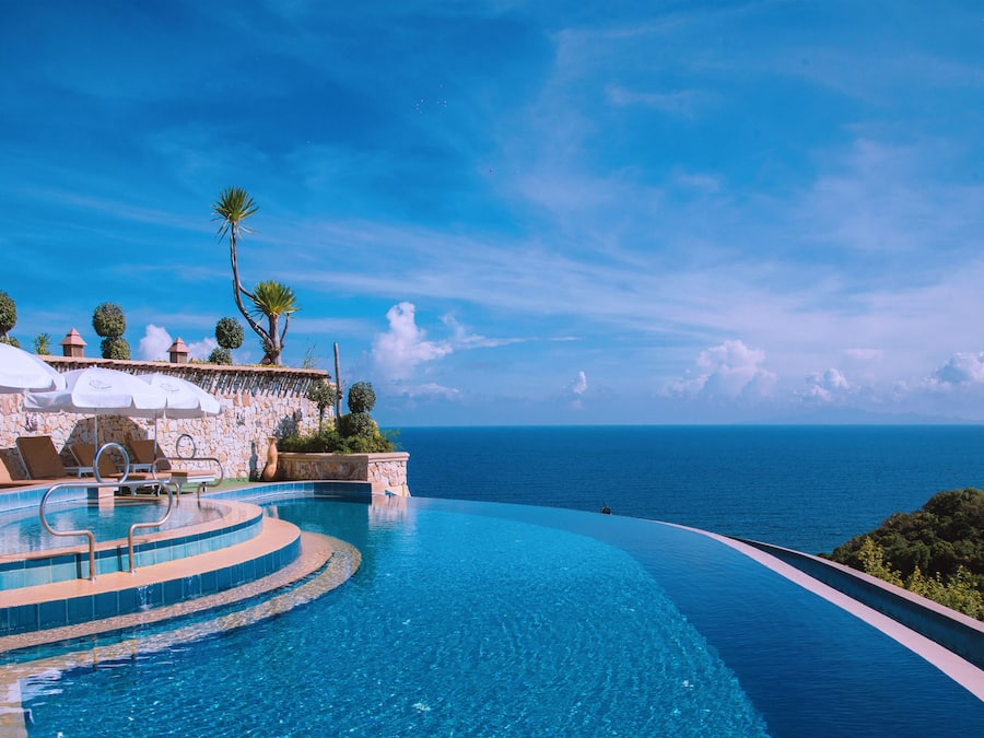 Una piscina al aire libre, sillones reclinables de piscina