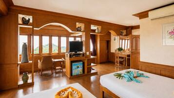A room with a bed, a desk, a television, and a view of the outdoors.