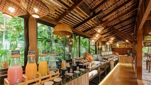 A buffet bar with various juice dispensers, a coffee station, and a view of greenery outside. - Aonang Fiore Resort (Krabi)
