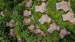An aerial view of a resort with multiple hexagonal structures surrounded by lush greenery and palm trees. - Aonang Fiore Resort (Krabi)