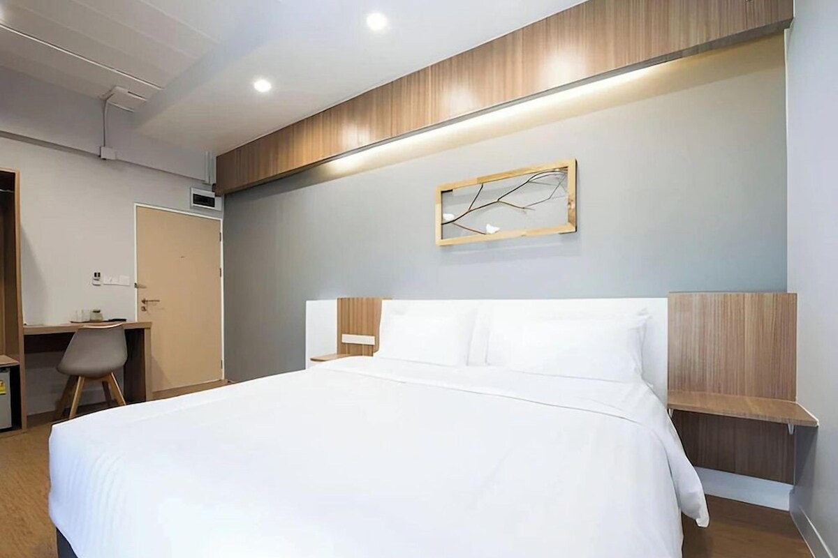Una habitación de hotel moderna con una cama grande, un escritorio y una silla.