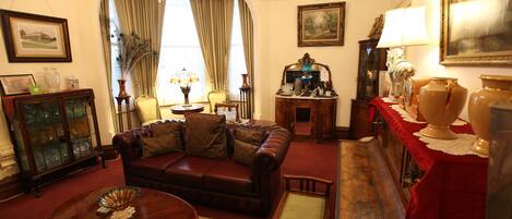 A traditional living room with a leather sofa, a wooden coffee table, and a chandelier.