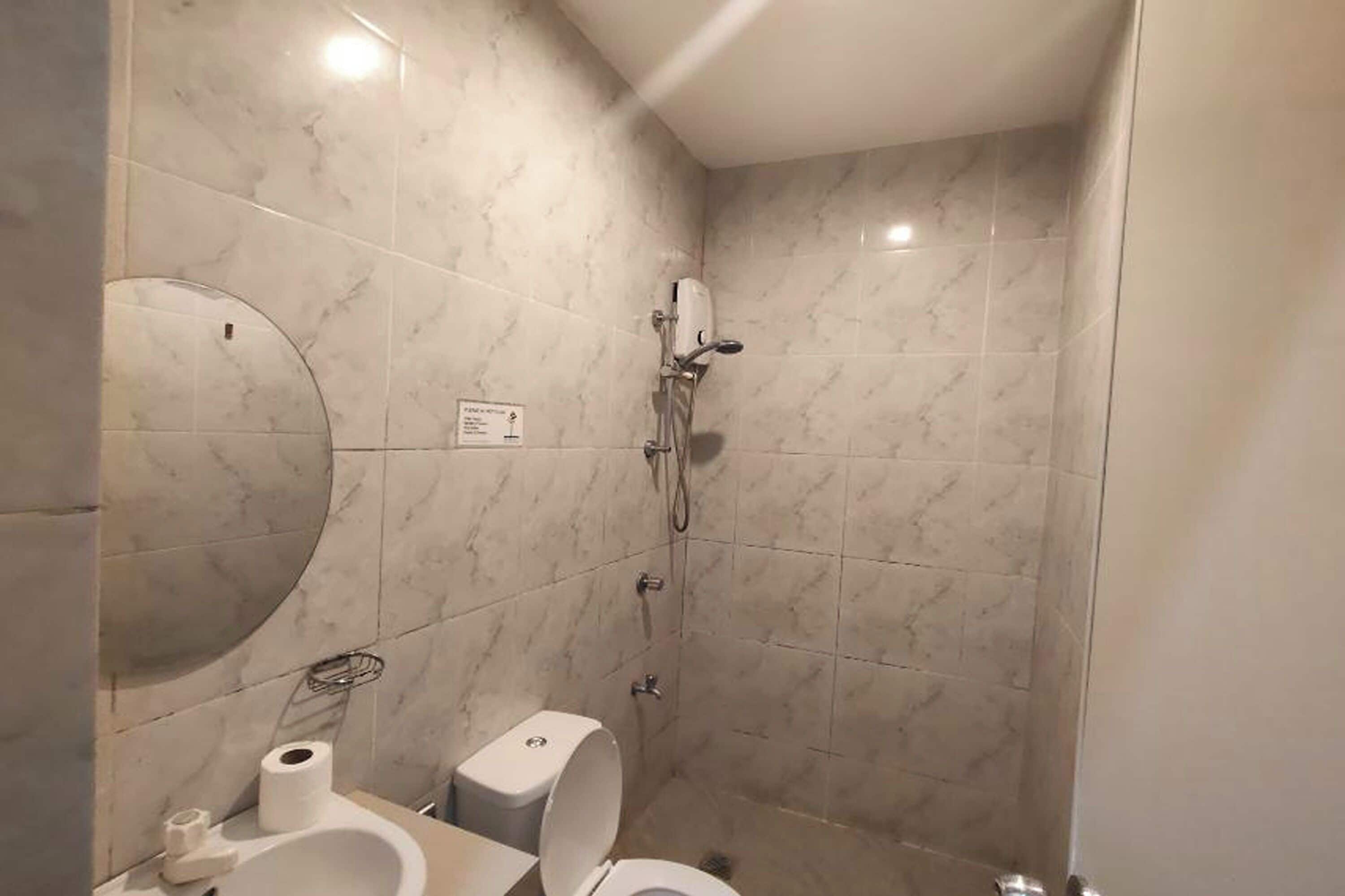 A bathroom with a toilet, a sink, and a shower.