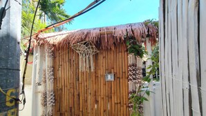 A wooden gate with a thatched roof, a hanging net, and a small light fixture. - Boracay Backpackers (Boracay Island)