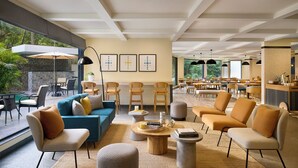 A spacious indoor area with seating arrangements, a dining area, and a view of the outdoors. - Spark by Hilton Goa Calangute (Calangute)