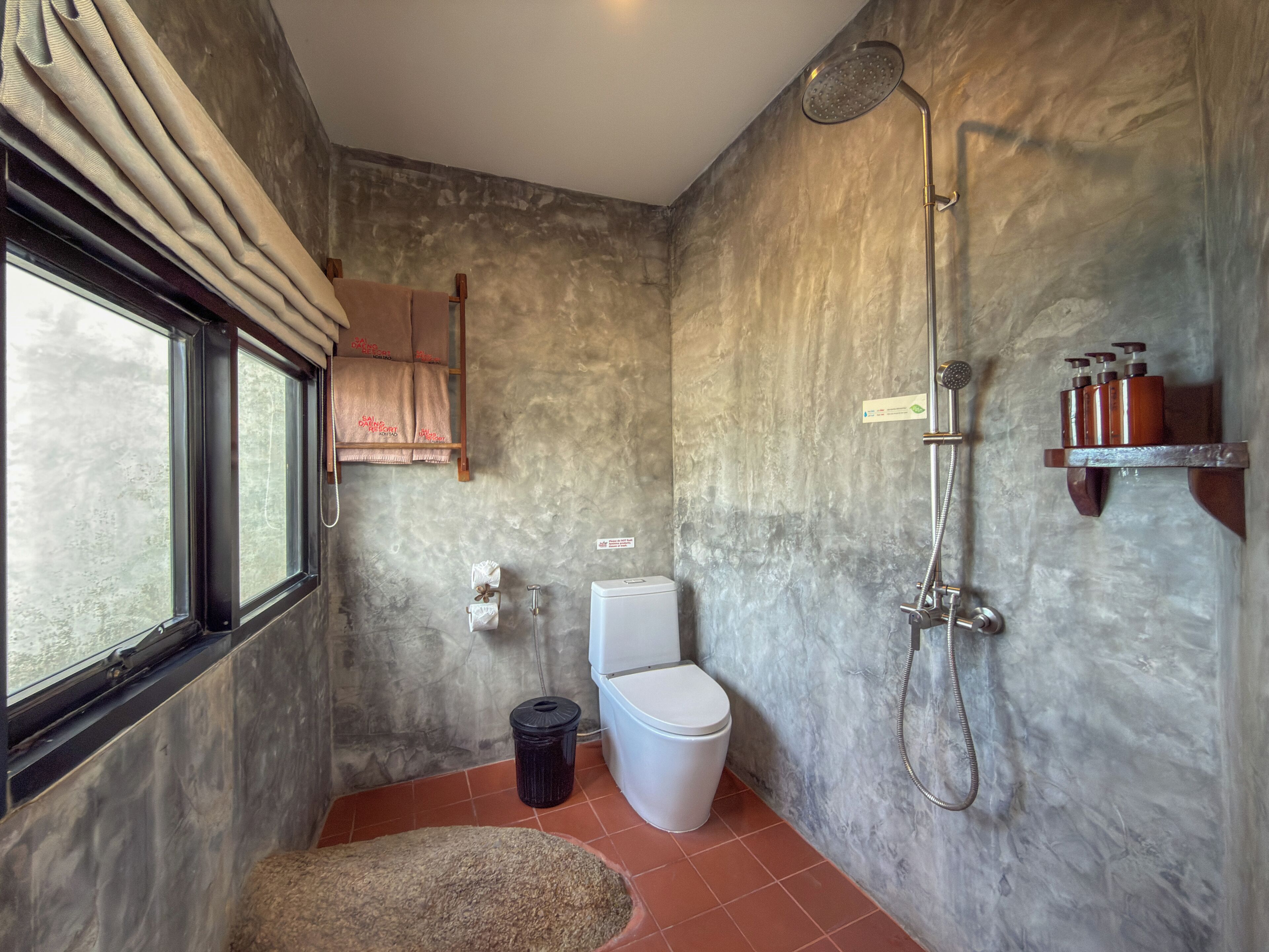 Un bagno con doccia, toilette e una finestra.