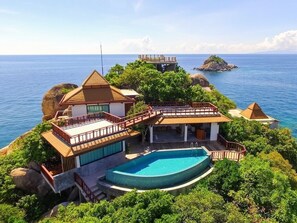 Una propiedad frente a la playa con piscina, terraza cubierta y vista al océano.