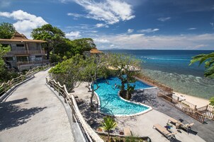 Ein Resort mit Pool, Liegestühlen und Blick auf den Ozean.
