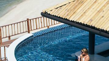 Un espace piscine avec vue sur une plage et une terrasse en bois.