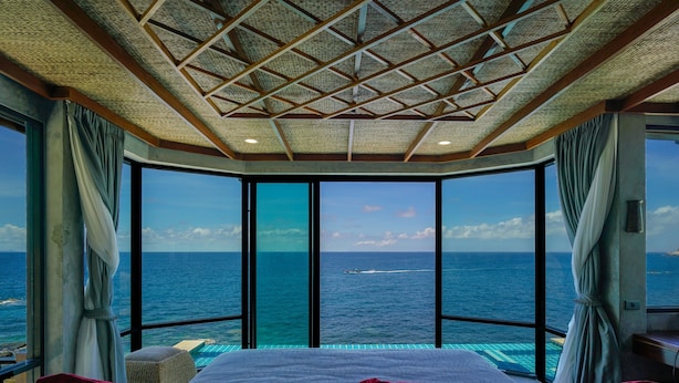 A room with a large bed, two windows, and a view of the ocean. - Sai Daeng Resort (Koh Tao)
