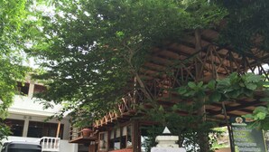 A covered outdoor area with a sign listing day tours and tourist information. - Hotel Mango Garden (Kandy)
