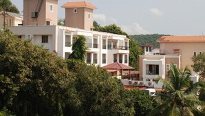 A residential area with multi-story buildings, some with balconies and red-tiled roofs.