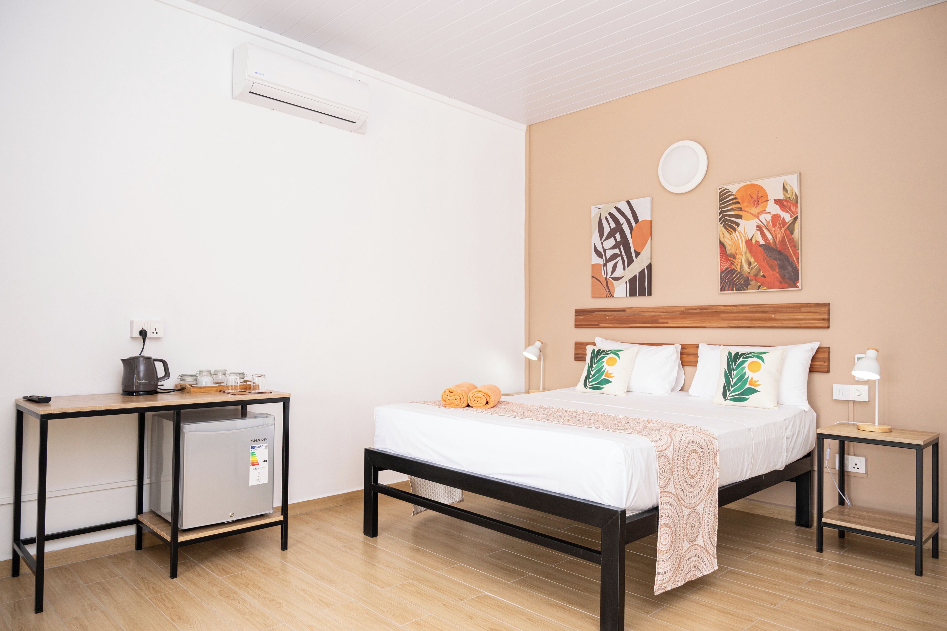 Une chambre d’hôtel comprenant un lit, des tables de chevet, un bureau et un réfrigérateur.