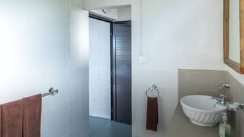 A modern bathroom with a white sink, a mirror, and a towel rack.