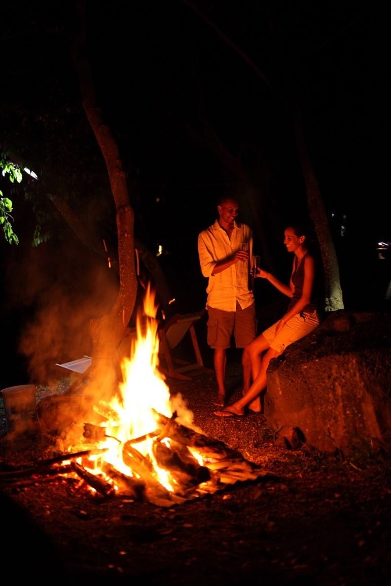 Un feu de camp avec deux personnes debout à proximité.