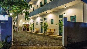 A hotel with a covered outdoor area, multiple windows, and a sign indicating it is a Colombo Beach Hotel. - Colombo Beach Hostel (Mount Lavinia)