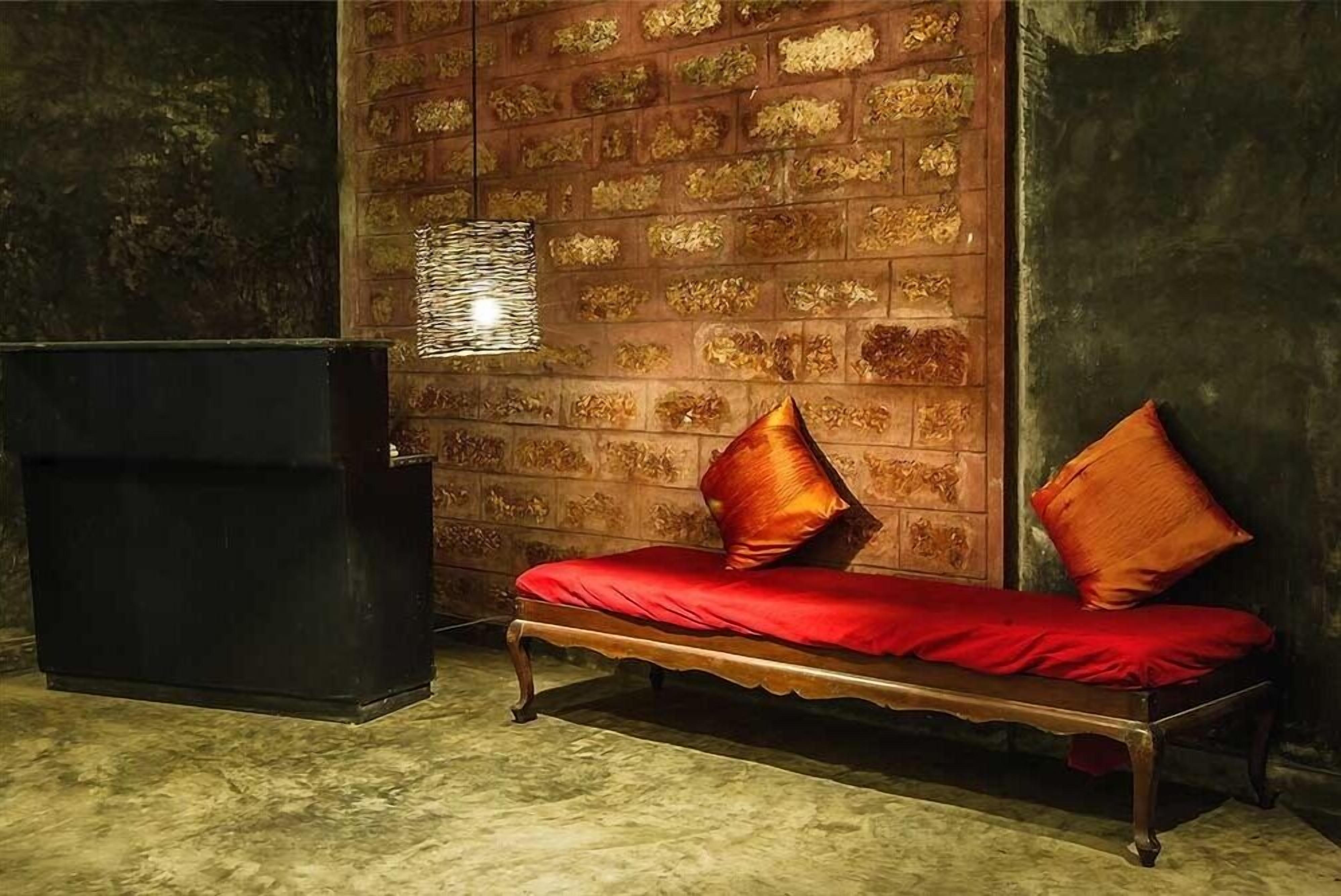 A room with a wooden bench, a black cabinet, and a patterned wall.