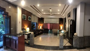 A hotel lobby with a reception desk, seating area, and a clock. - S.C. Heritage Hotel (Hat Yai)