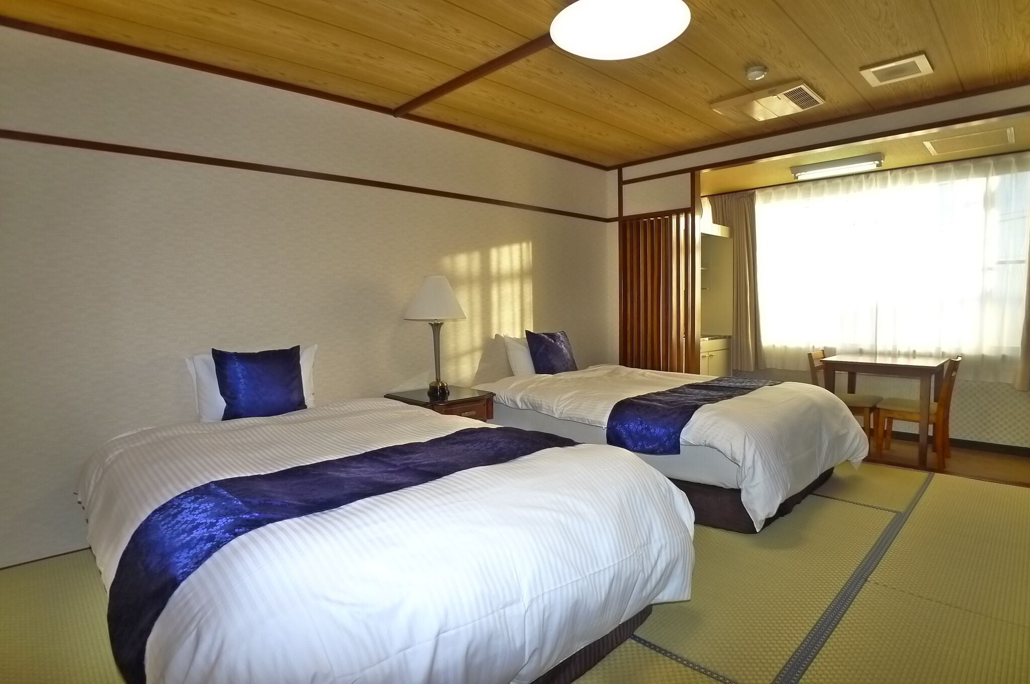 Habitación de hotel con dos camas, un escritorio y una silla.
