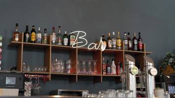 Zona de bar con estanterías llenas de botellas de licor y vasos.