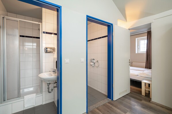 Un baño moderno con ducha, lavamanos e inodoro.