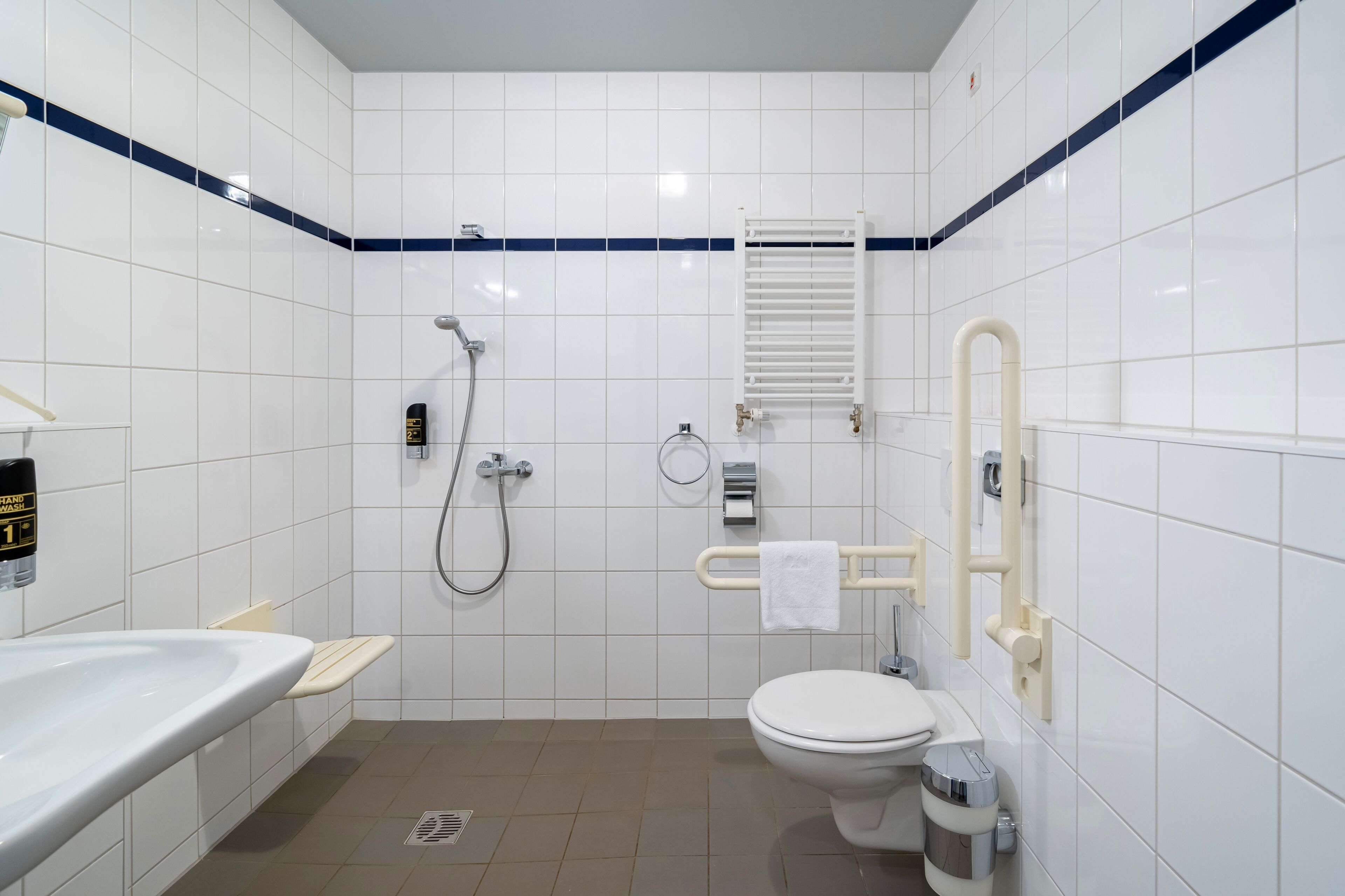A modern bathroom with a white sink, toilet, and shower.