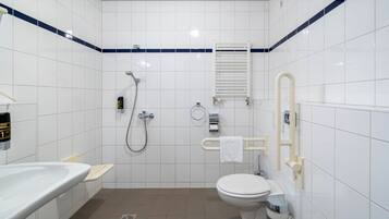 A modern bathroom with a white sink, toilet, and shower.
