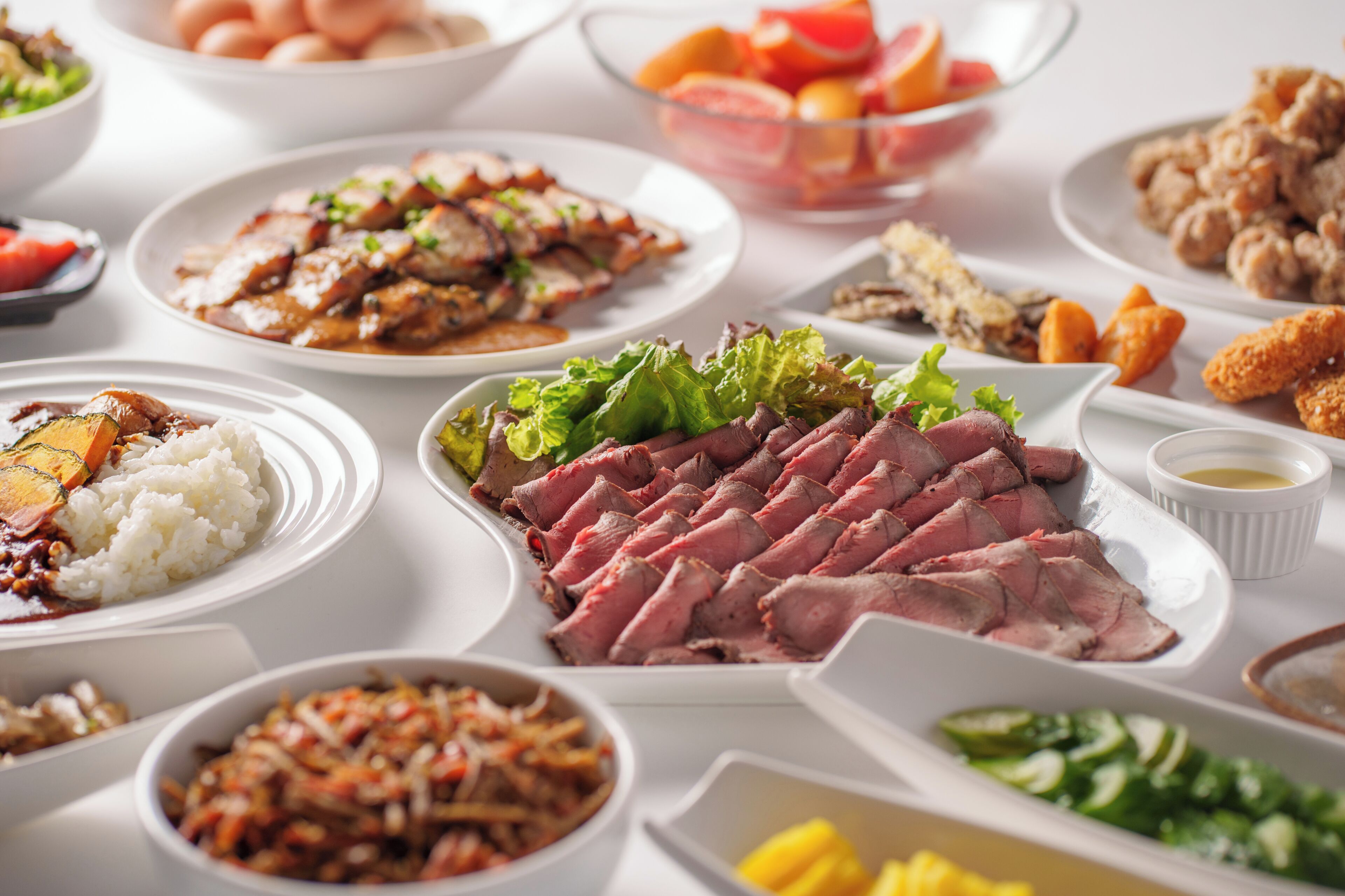 Variedad de platos con carne, arroz y verduras sobre una mesa.