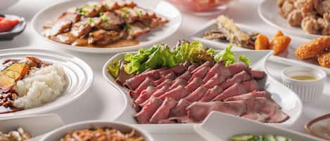 Variedad de platos con carne, arroz y verduras sobre una mesa.