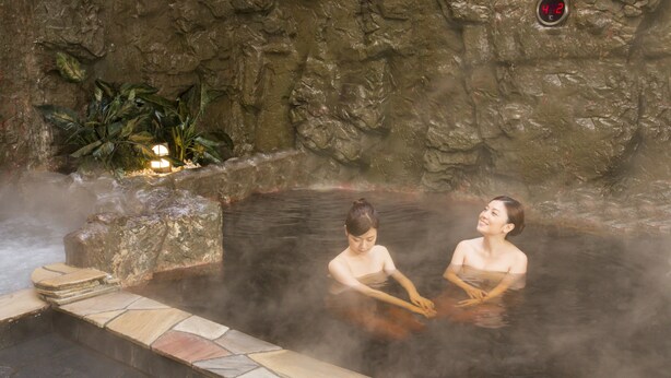 A hot spring area with stone steps and a rocky wall. - Premier Hotel Cabin Obihiro (Obihiro)