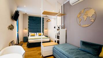 Una habitación de hotel moderna con una cama, un sofá, un escritorio y una televisión.