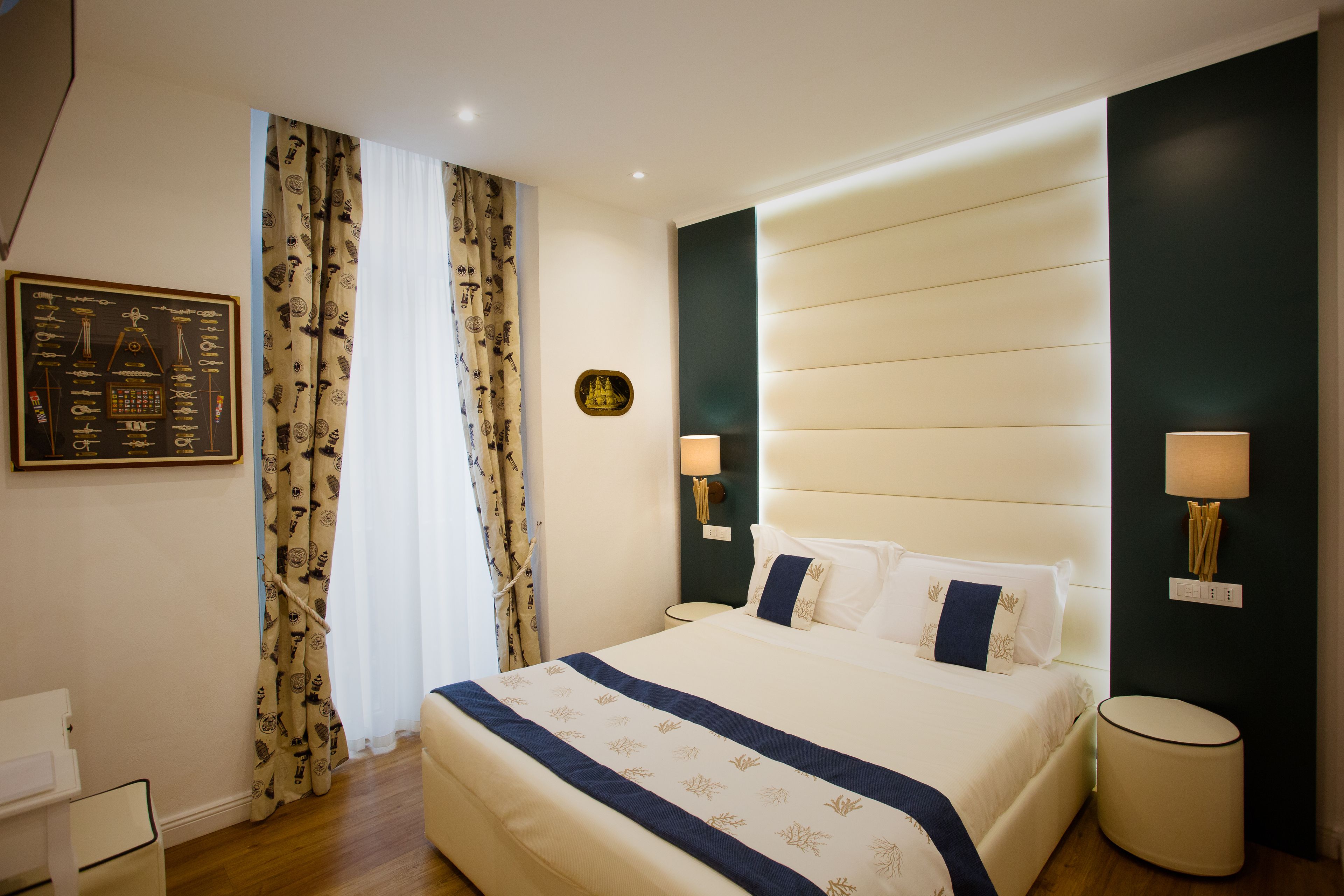 Une chambre d’hôtel bien aménagée, avec un grand lit, deux lampes de chevet, une table de nuit et une horloge fixée au mur.