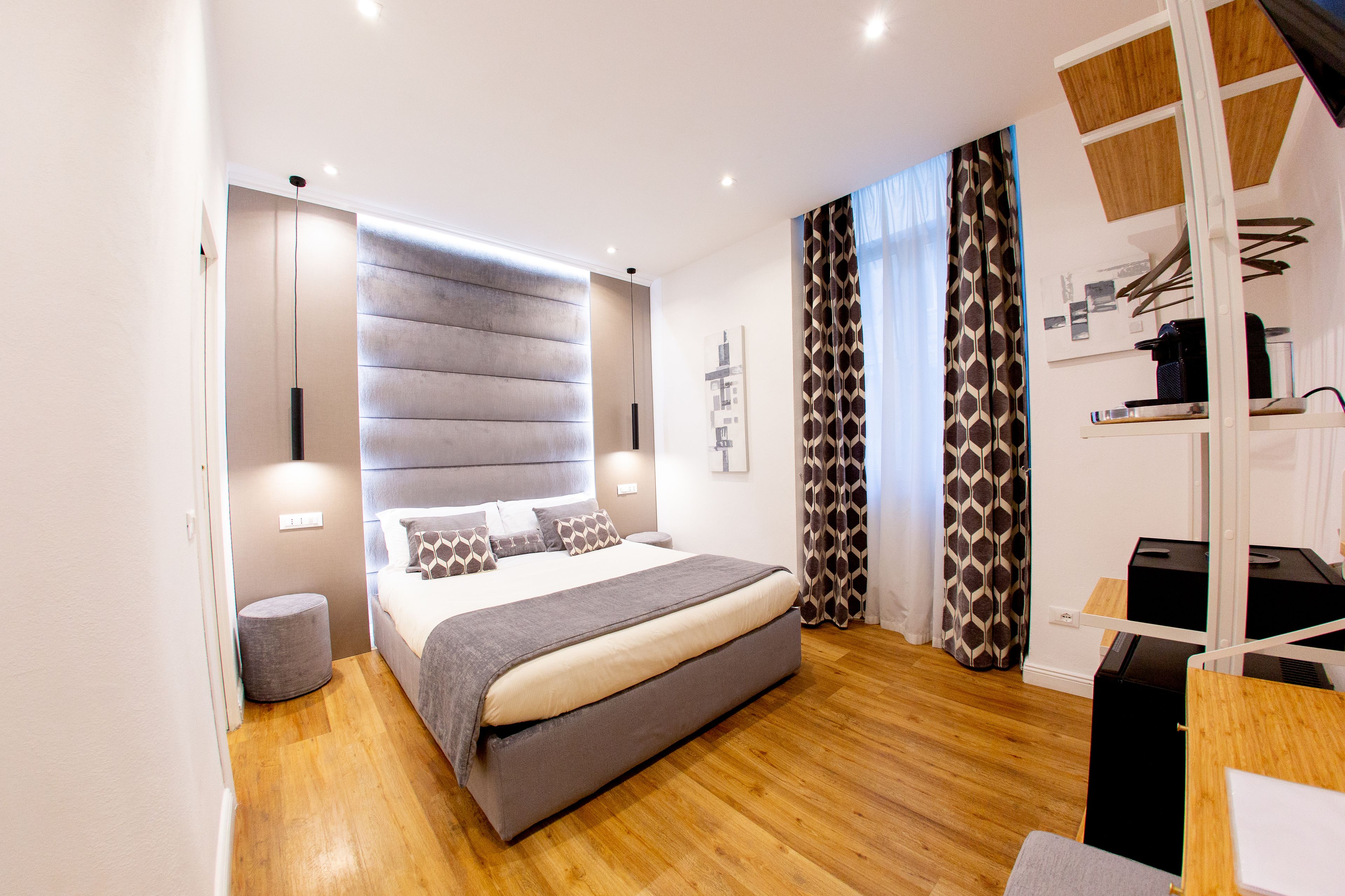 Un dormitorio moderno con una cama grande, una mesita de noche, un armario y un escritorio con silla.