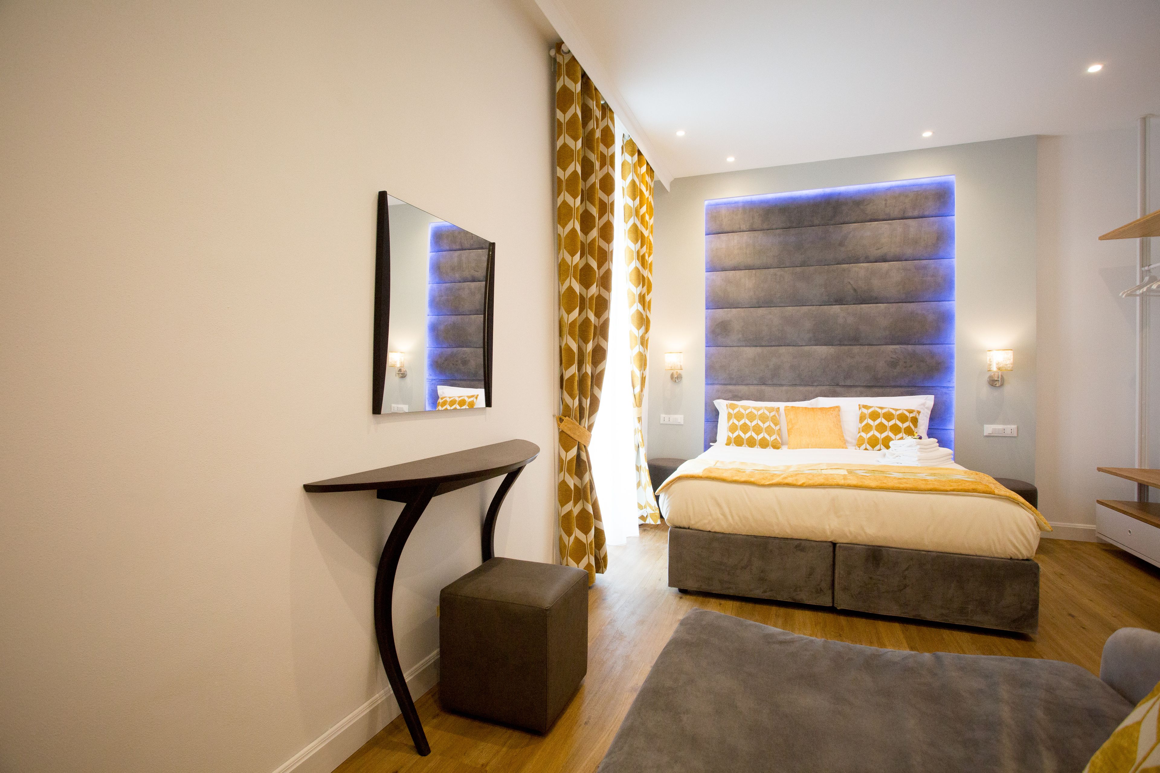 Un dormitorio moderno con cama, mesitas de noche, un escritorio y una silla.