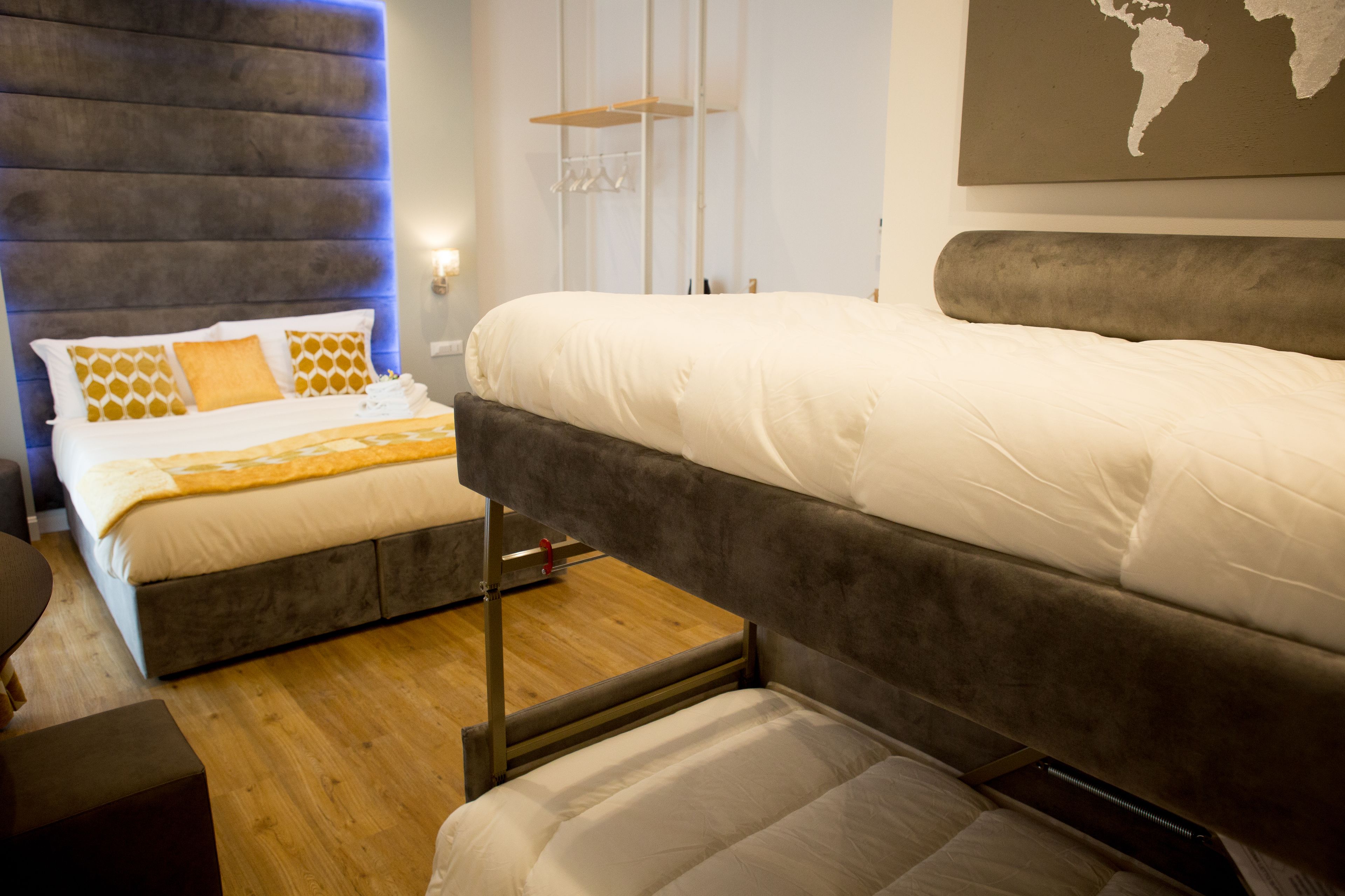 Ein modernes Hotelzimmer mit einem großen Bett, einem kleineren Bett und einem Holzboden.