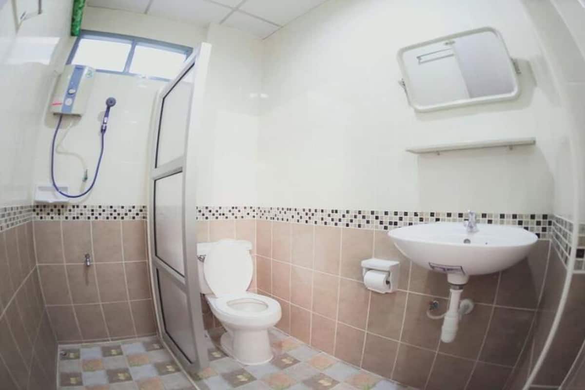 A small bathroom with a toilet, sink, and shower.