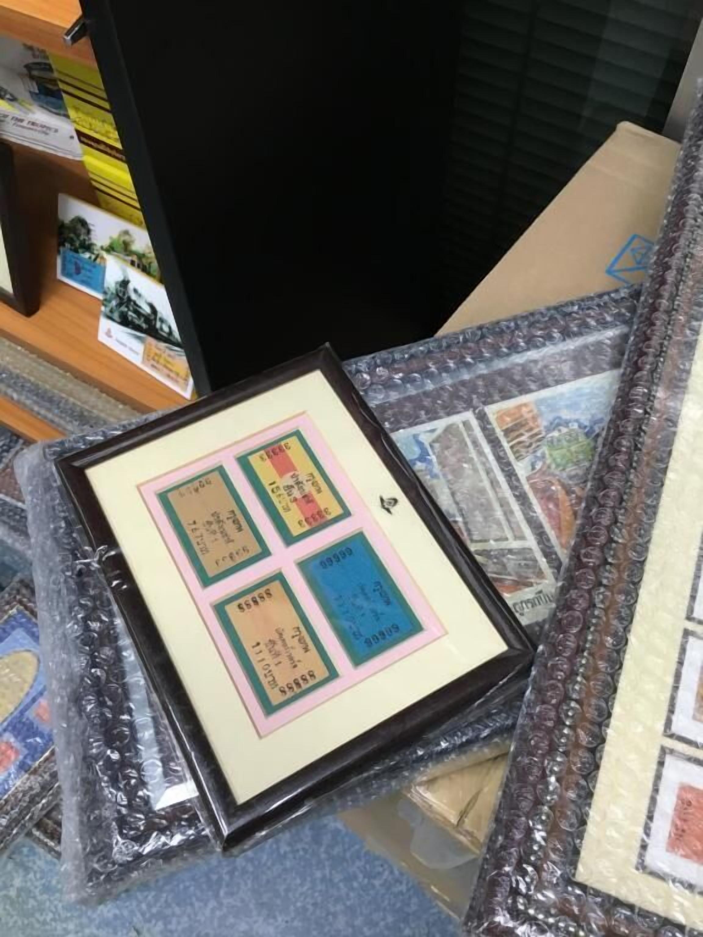 A framed item with text and numbers, placed on a surface with a patterned border.