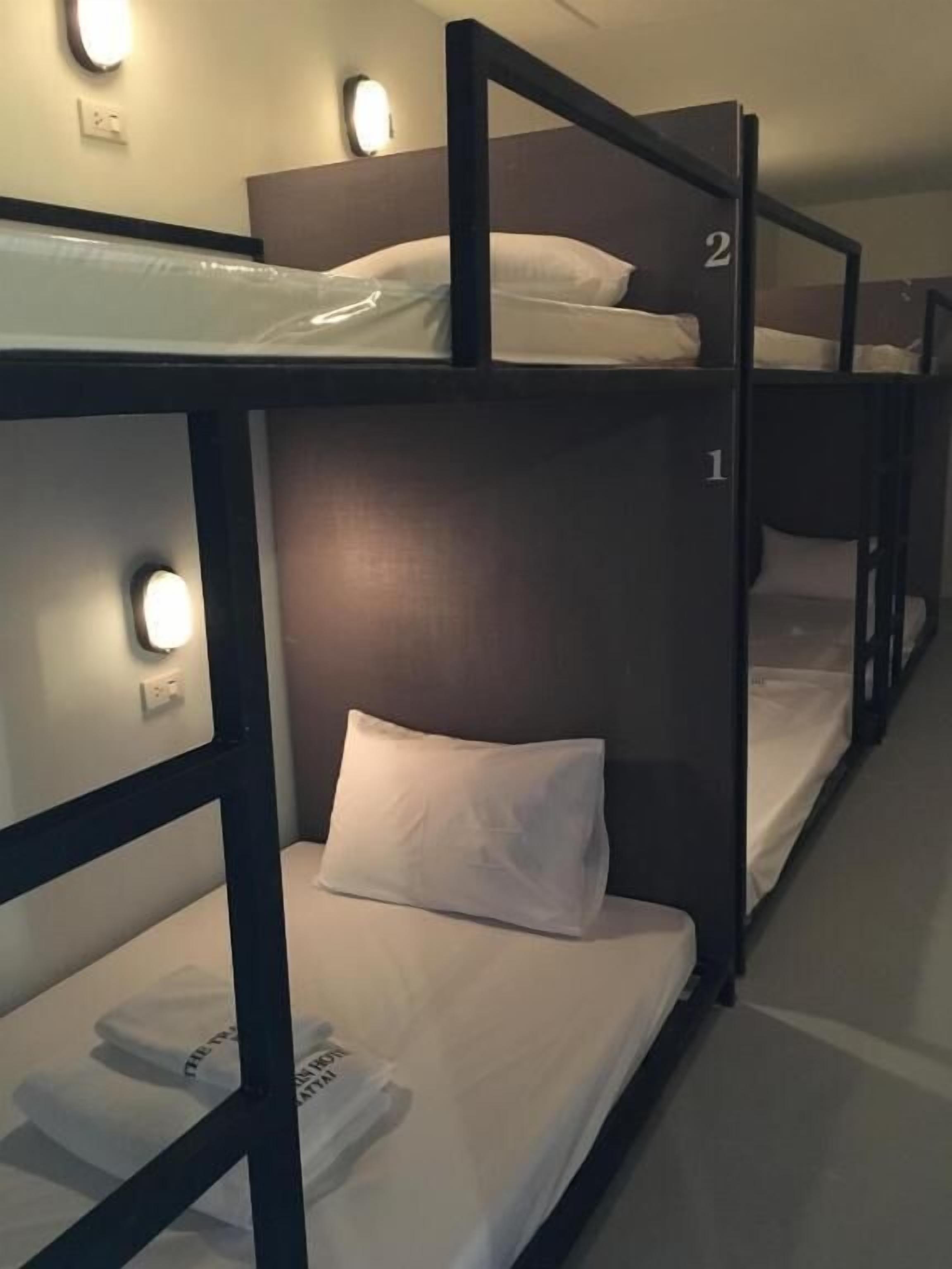 A bunk bed room with two levels, each with a pillow and a neatly folded towel.