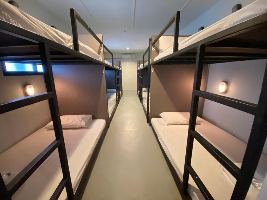 A corridor with bunk beds, each with a number.
