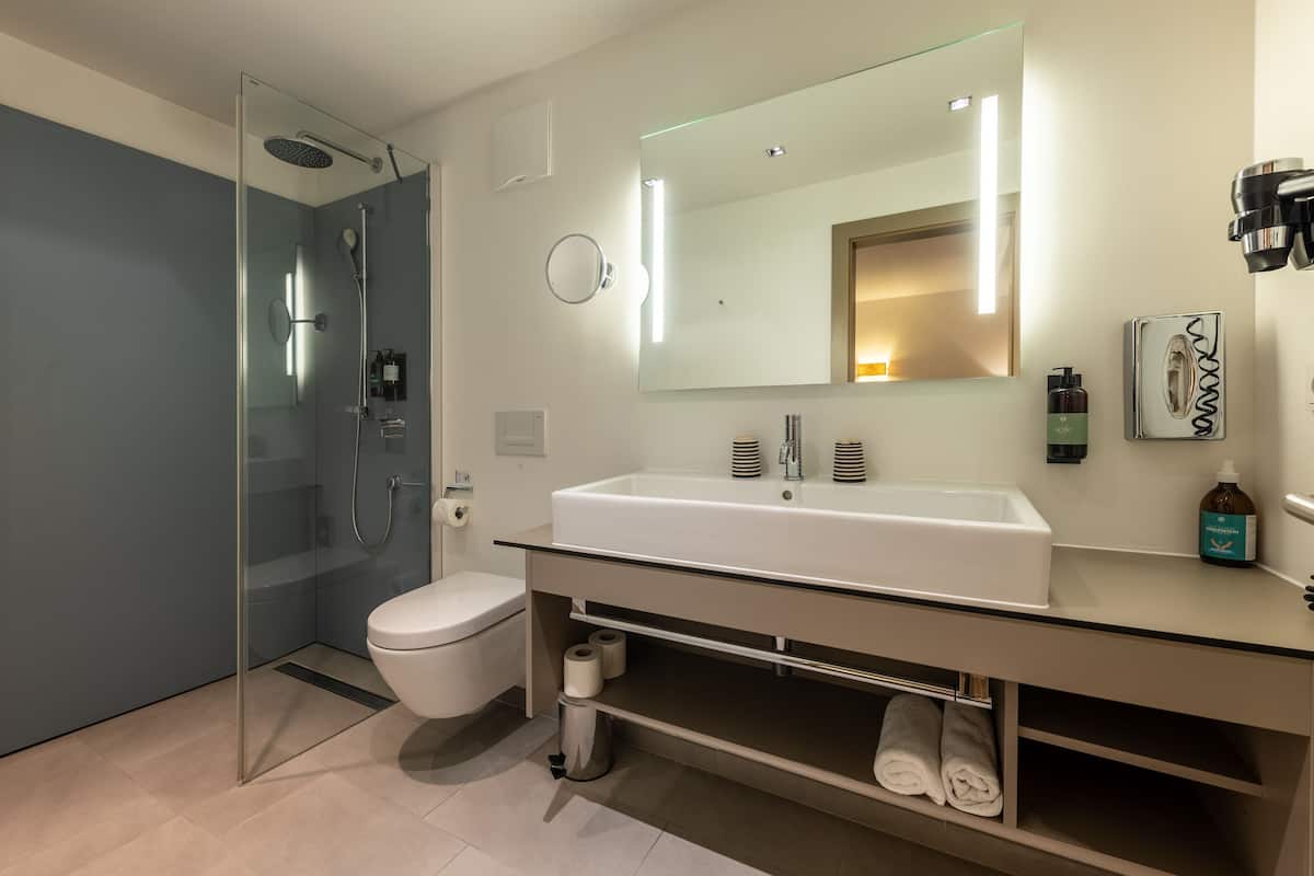 junior suite | bathroom | shower, free toiletries, hair dryer, bathrobes