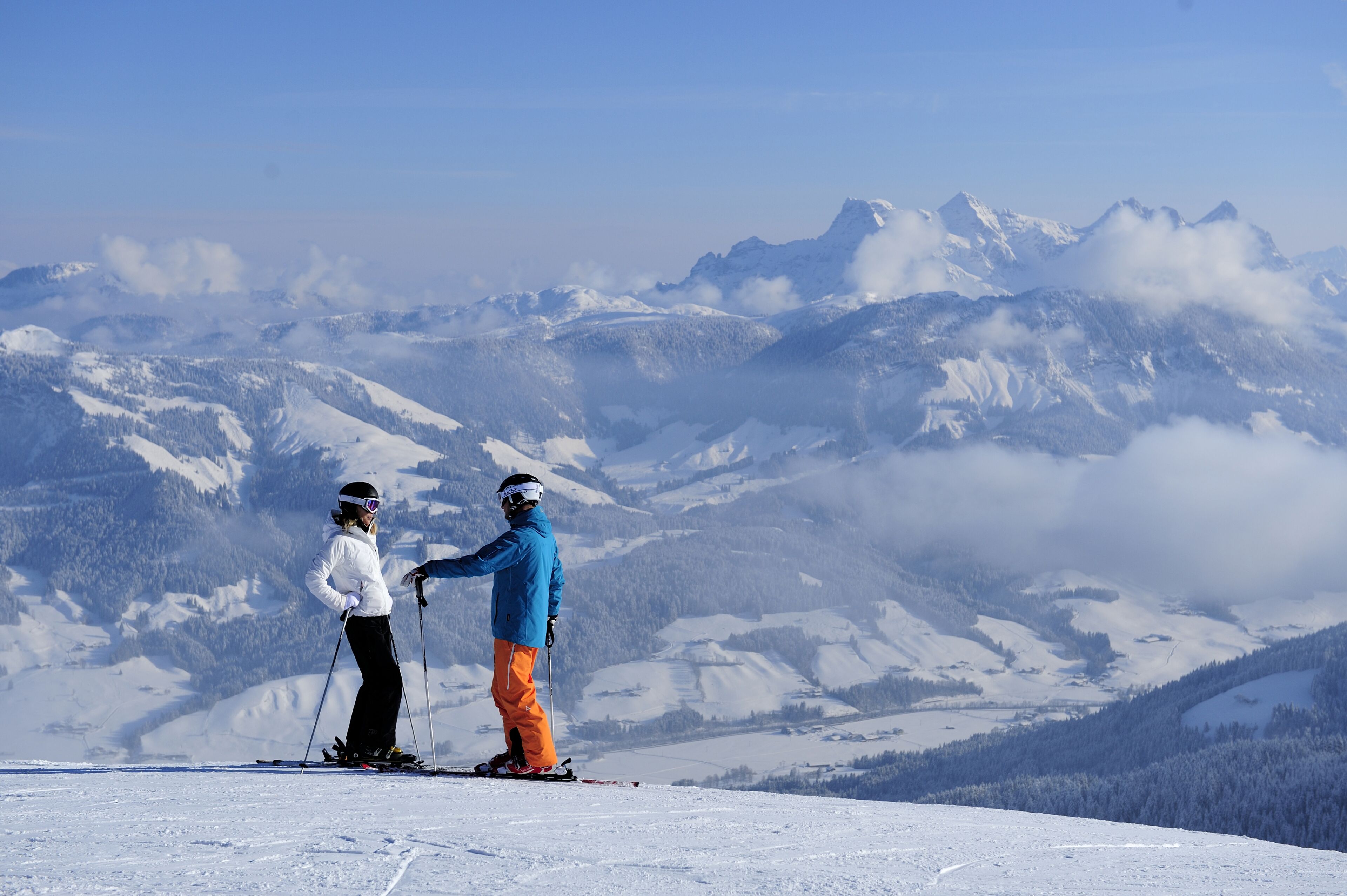 A snowy mountain landscape with skiers.