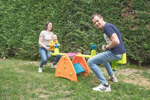 A family playing on a playground with a slide and climbing structure. - La Rosa Gialla (Barolo)