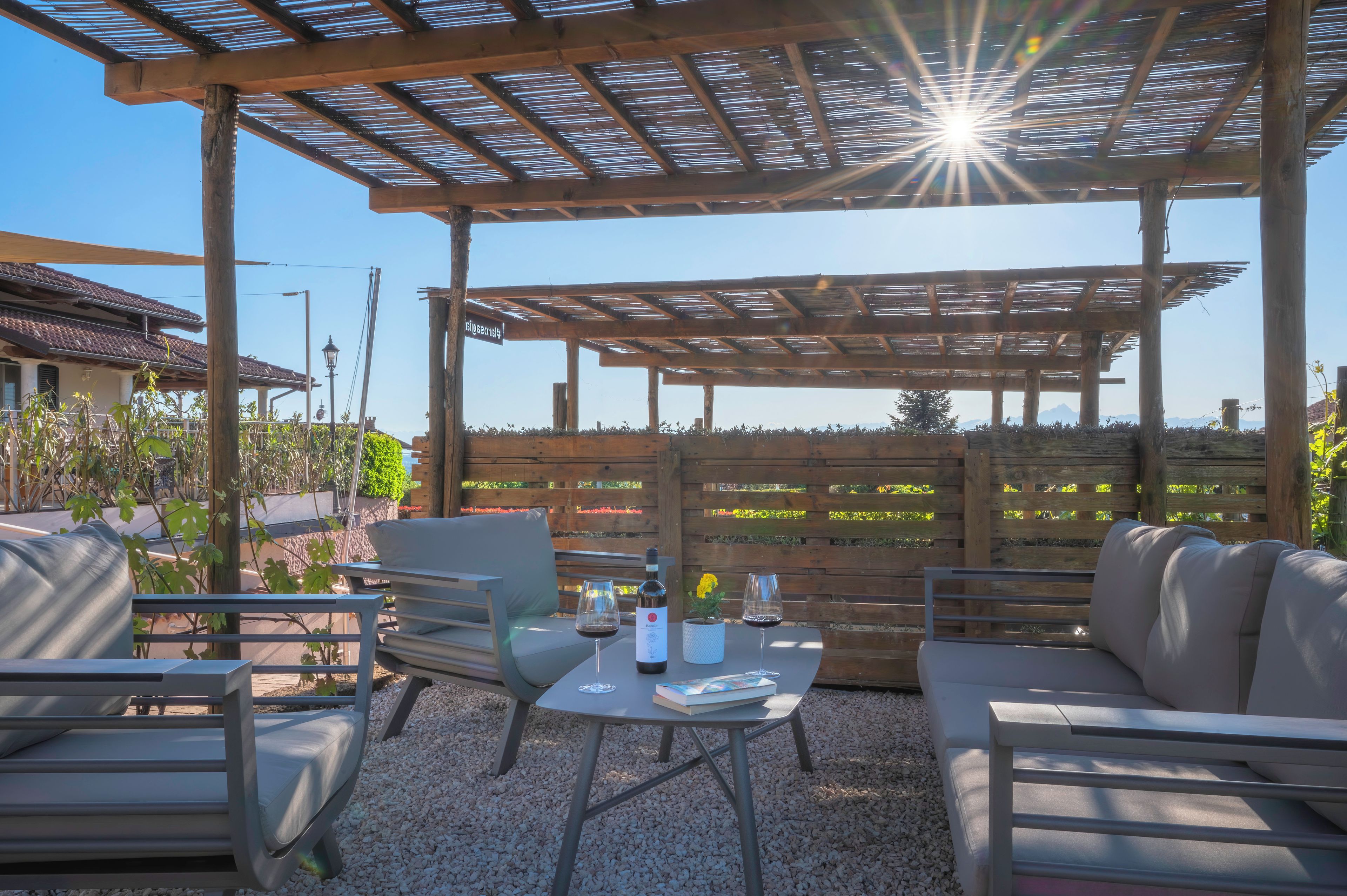 Un espace extérieur aménagé avec une pergola, des tables et des chaises.