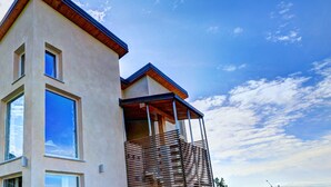 Un bâtiment moderne à deux étages, doté de grandes fenêtres et d’un balcon en bois.