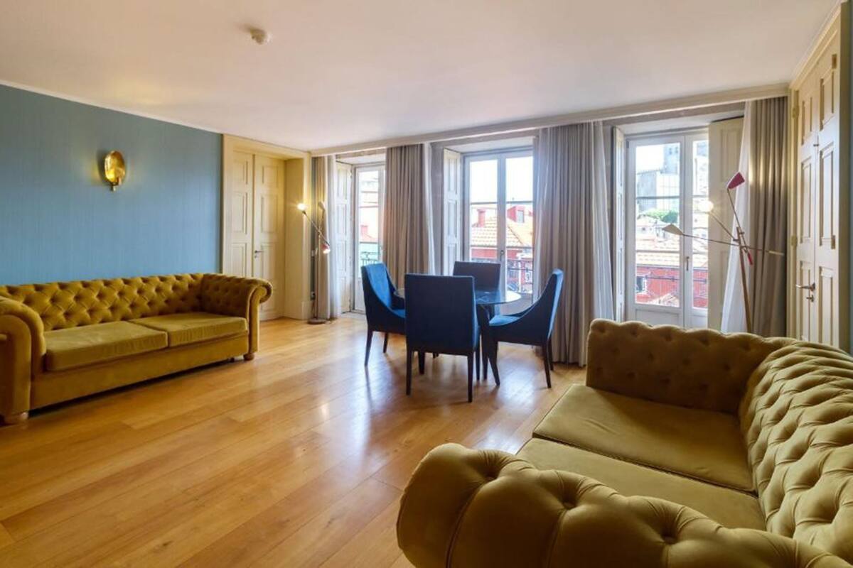 A spacious living room with a yellow sofa, a blue chair, and a table.