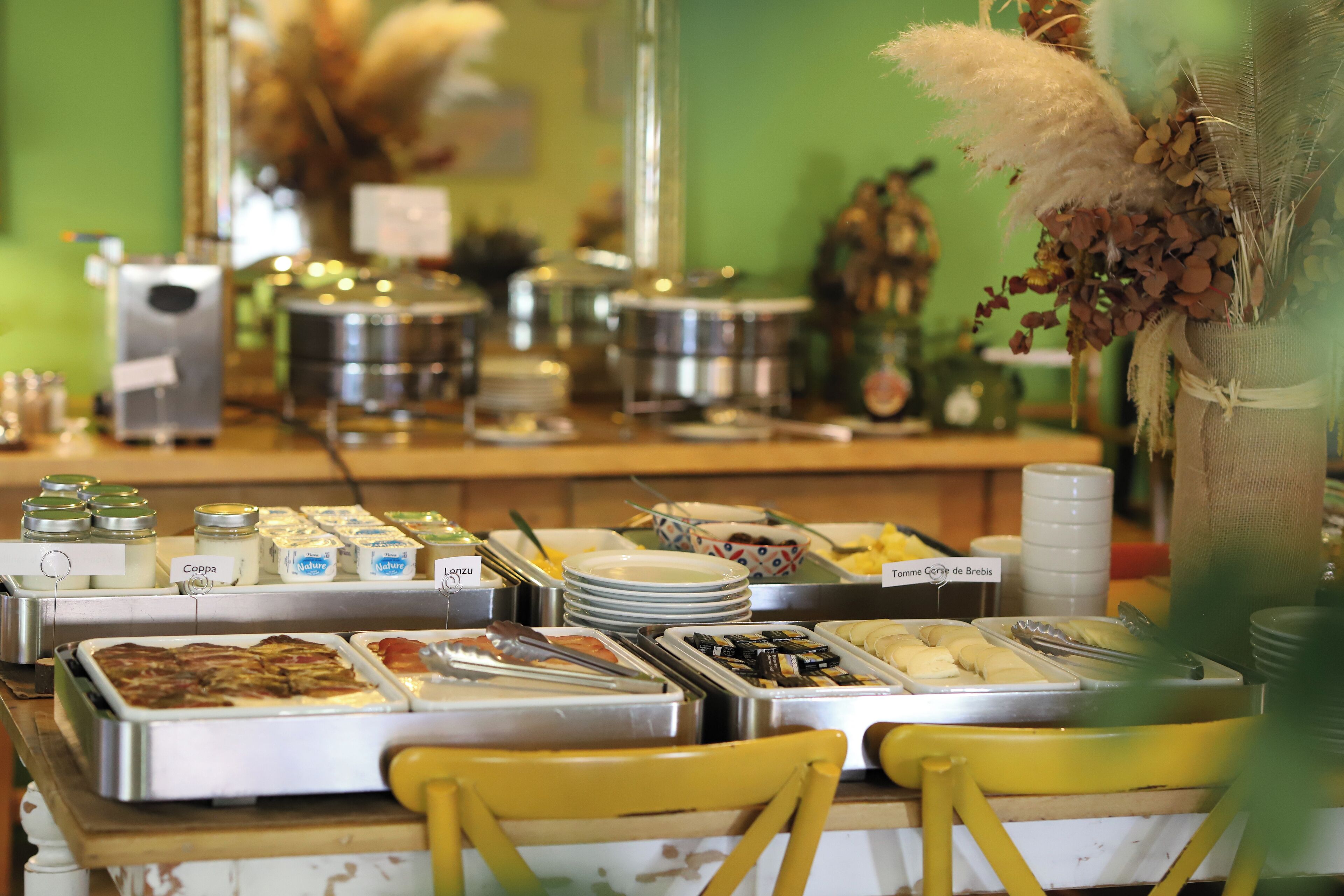 A buffet setup with various food items and condiments.